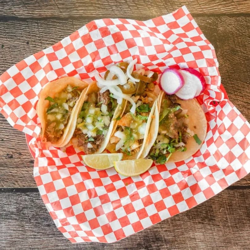 Four Antonio's Quick Lunch tacos with meat, onions, cilantro, limes, radishes, and jalapeños.